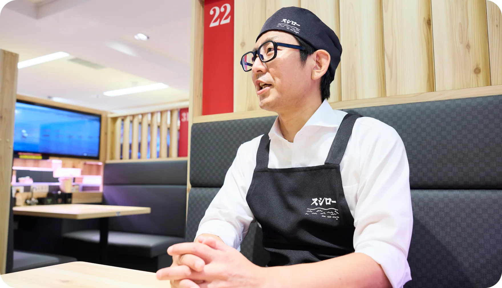 客席で笑顔で話す花輪博行